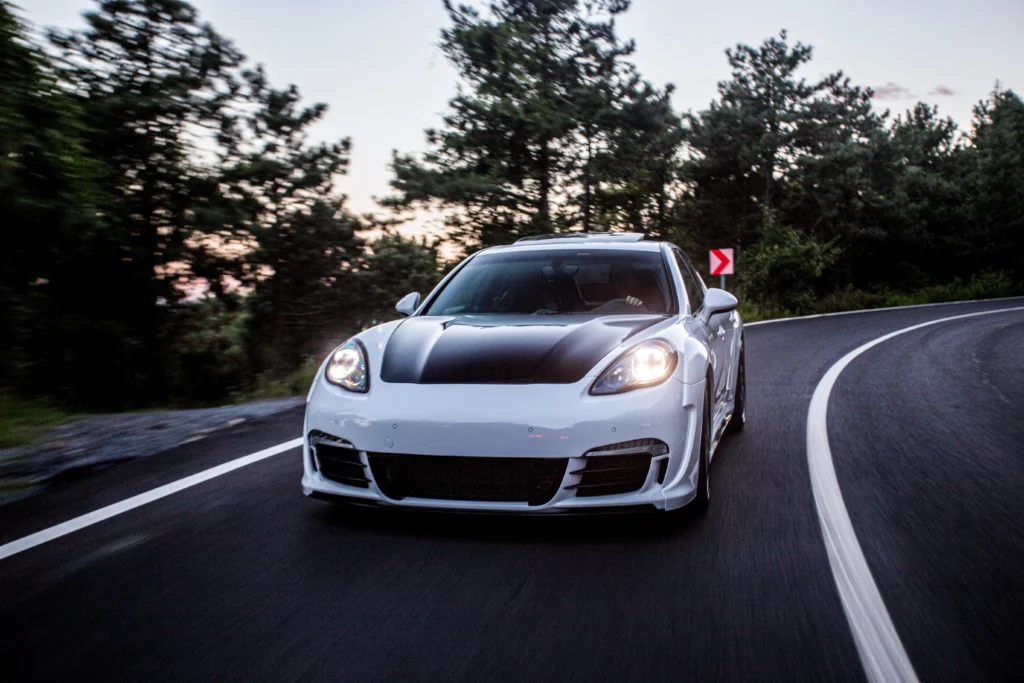 white sport car with black autotuning driving road